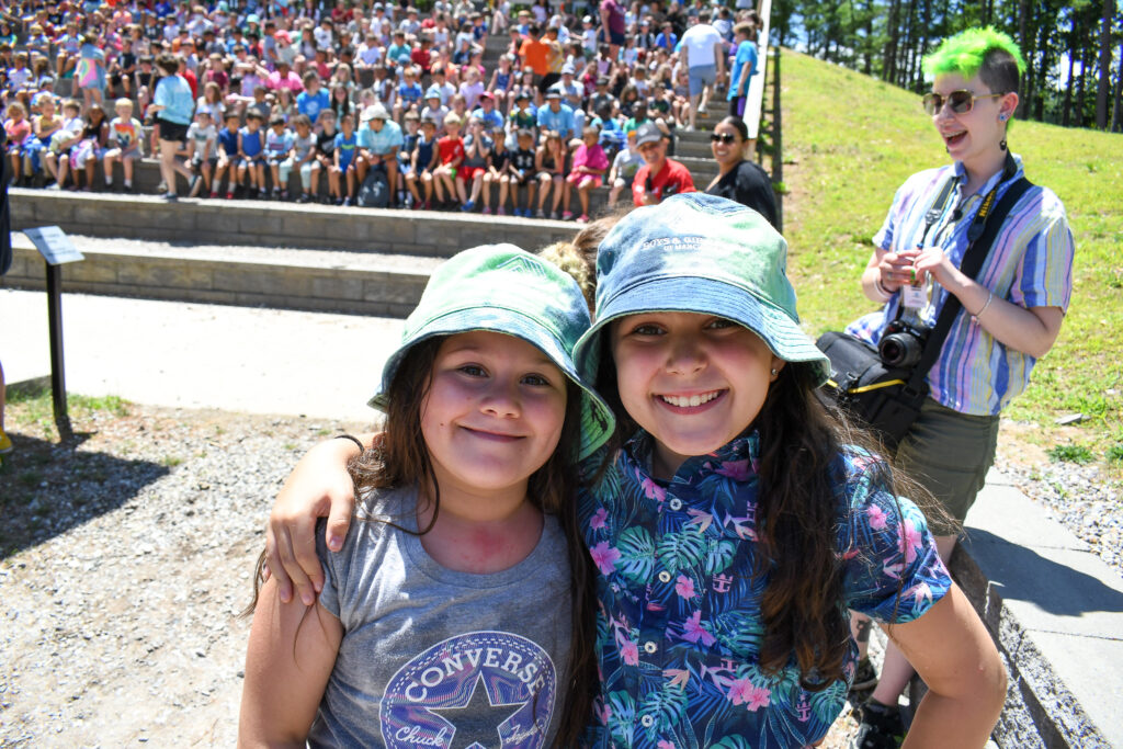 Two kids in bucket hats at an outdoor assembly